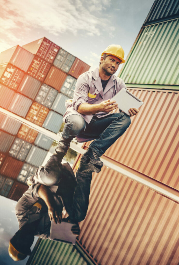 construction worker crouched down at a doc looking at a notebook