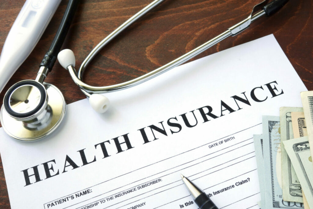 health insurance form on table with money and a stethoscope