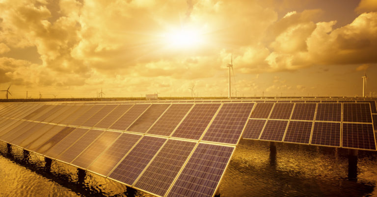 solar power panels with sun set in the background highlighting green energy.