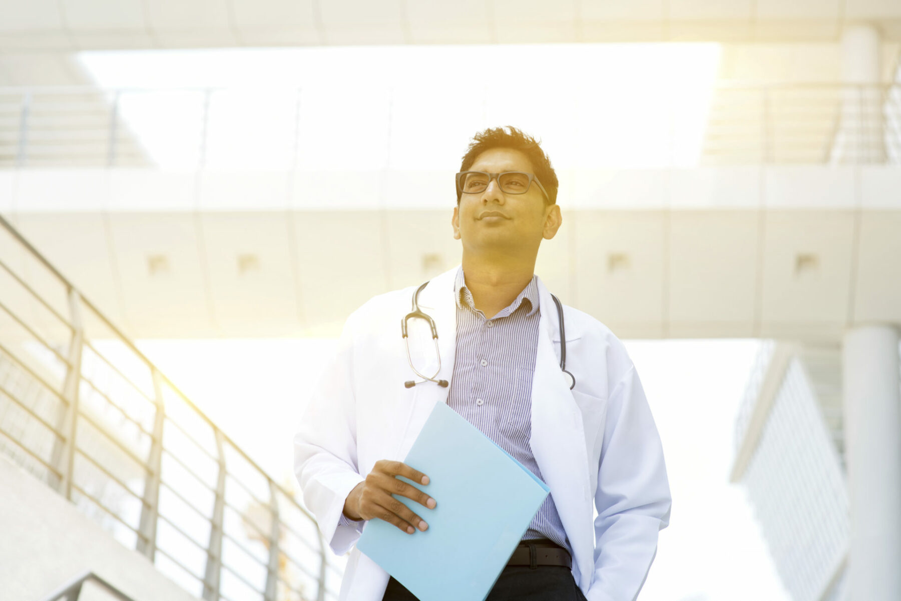 Portrait of Asian Indian medical doctor standing outside hospital building