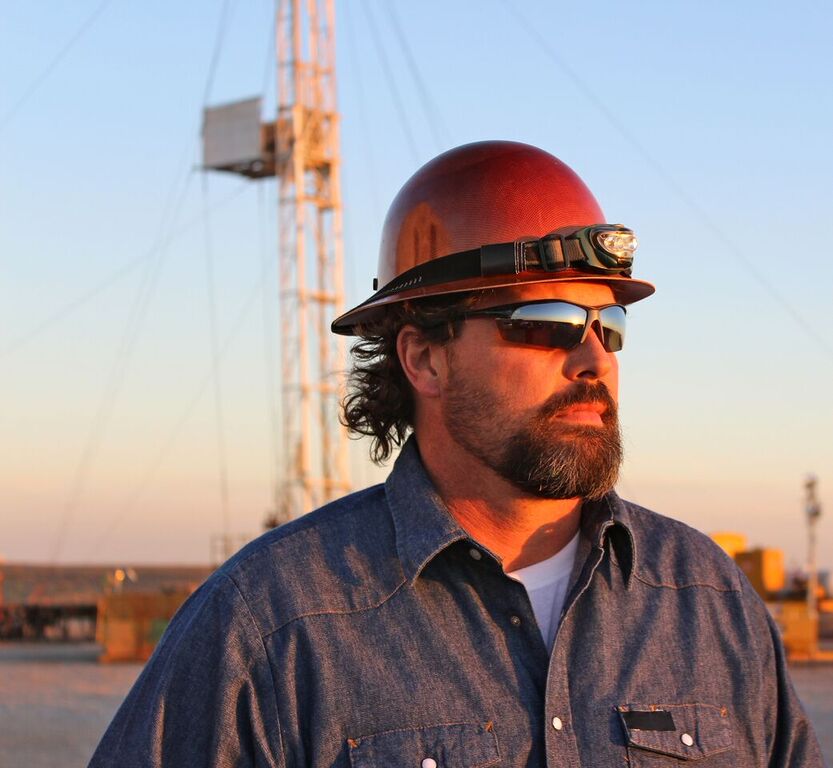construction worker with sunglasses looking forward with blue sky in the background
