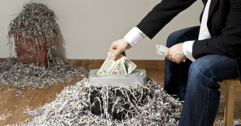 Man shredding one hundred dollar banknote