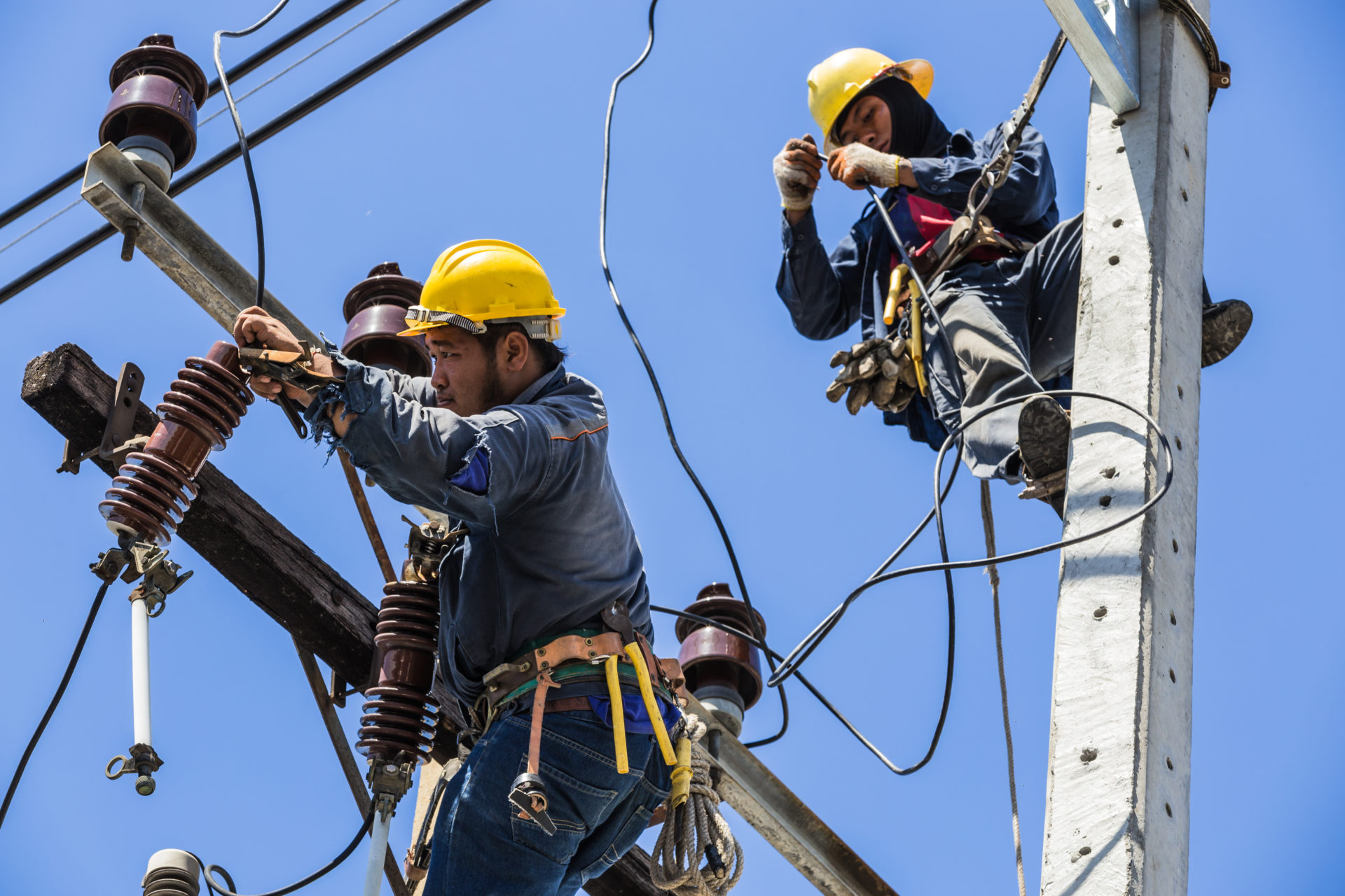 Electricians working together on the electricity pole