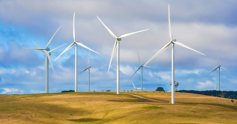 Wind turbine farm windmills creating energy on top of hill