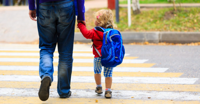 father with little daughter walking to school or daycare