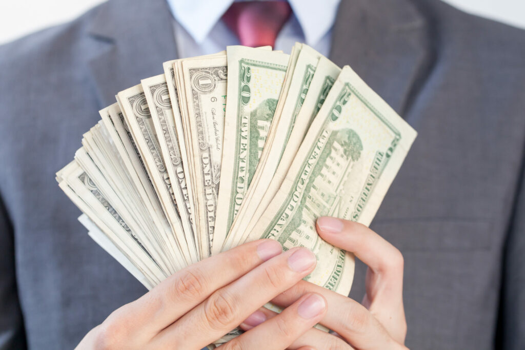 Businessman holding bank notes in white isolated background