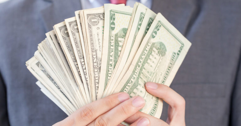 Businessman holding bank notes in white isolated background