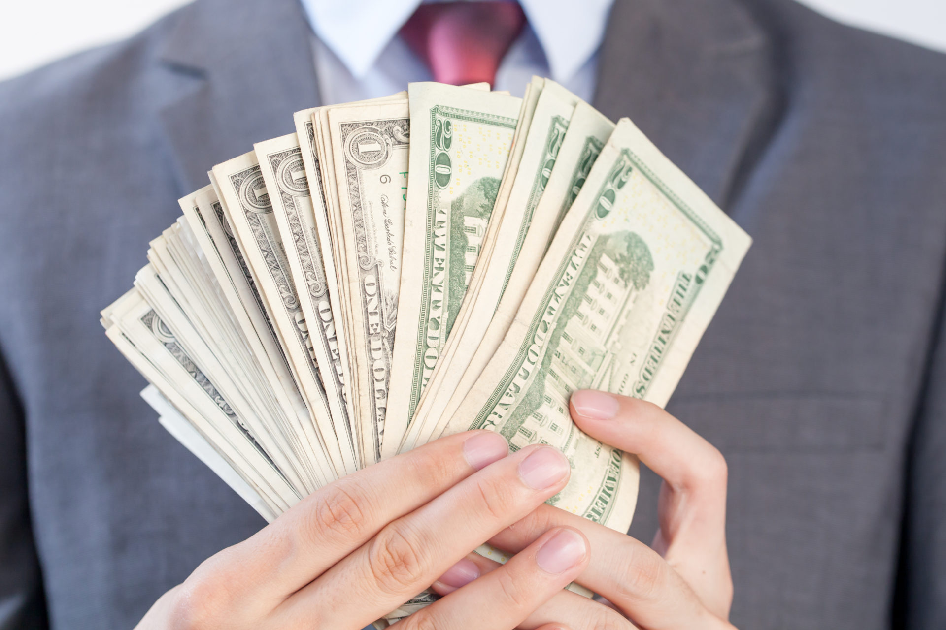 Businessman holding bank notes in white isolated background