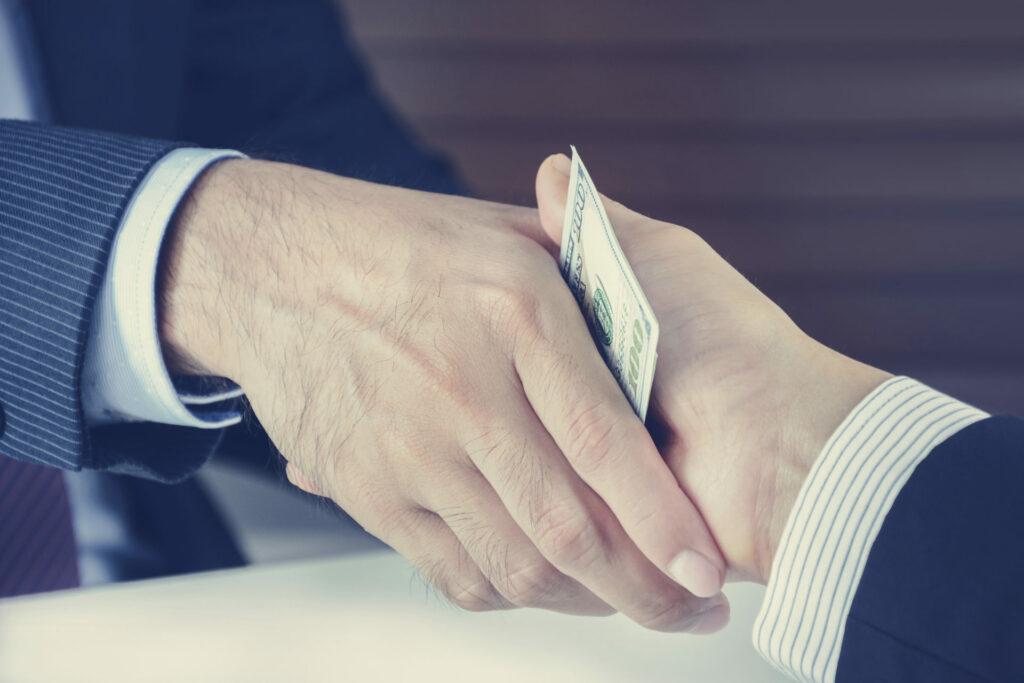 Handshake of businessmen with money