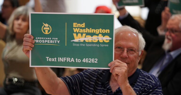 An AFP activist holds up a sign urging Washington to stop the spending spree at an End Washington Waste event in Dallas