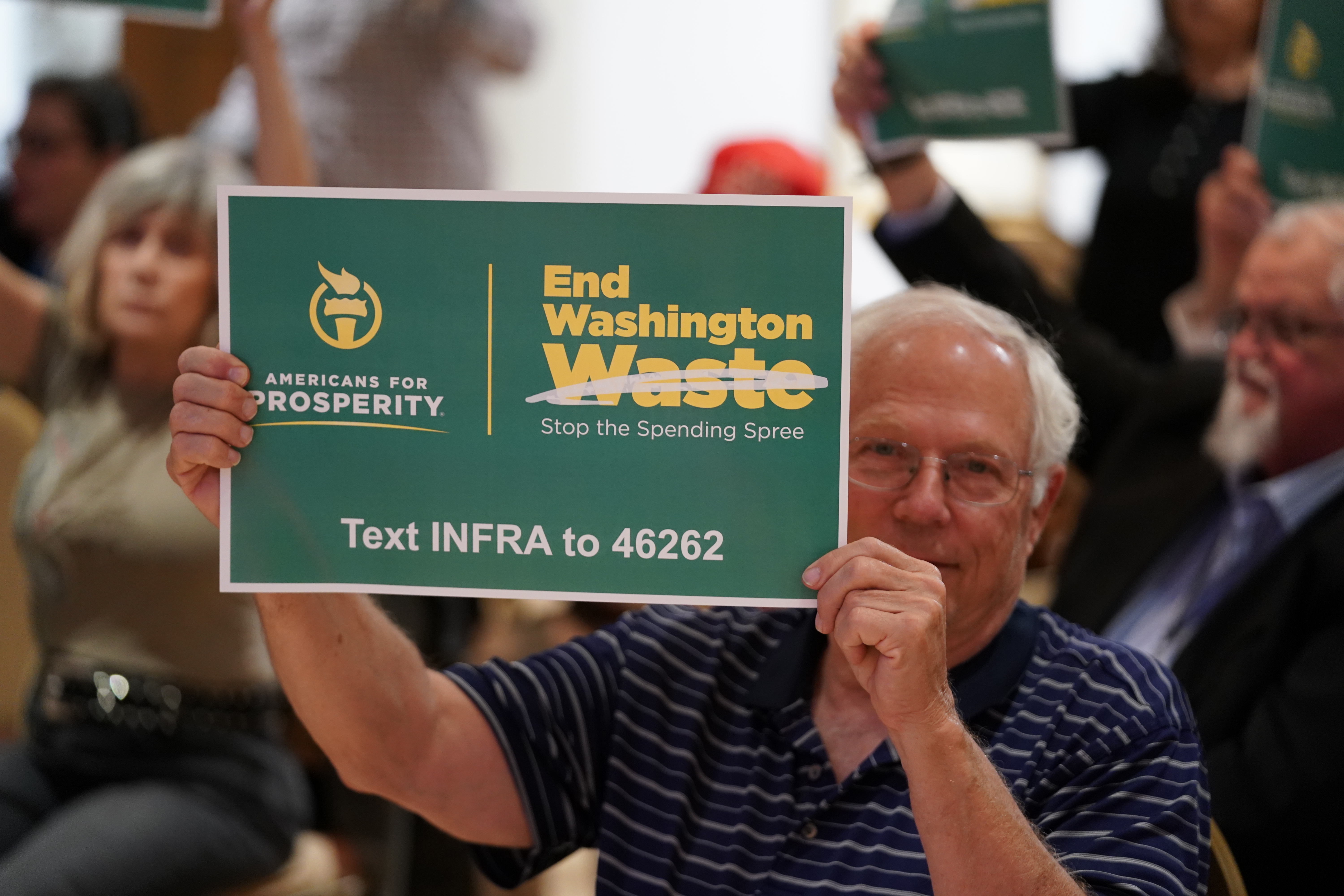 An AFP activist holds up a sign urging Washington to stop the spending spree at an End Washington Waste event in Dallas