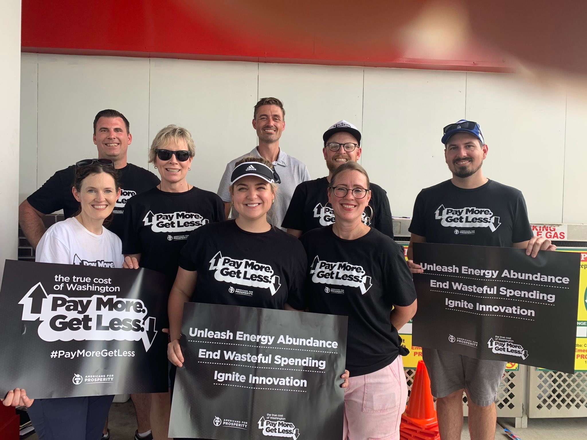 Americans for Prosperity Activists hold up signs that read, "Pay More, Get Less," the slogan for AFP's True Cost of Washington Tour to lower the cost of living in America. The activists are standing with AFP Managing Director Kent Strang (back row, center) who appeared on the Guy Benson show to explain to listeners what the True Cost Tour was all about.