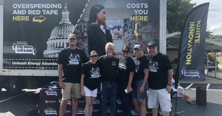 Americans for Prosperity-Pennsylvania activists stand in front of the True Cost of Washington Tour truck, which reads, 