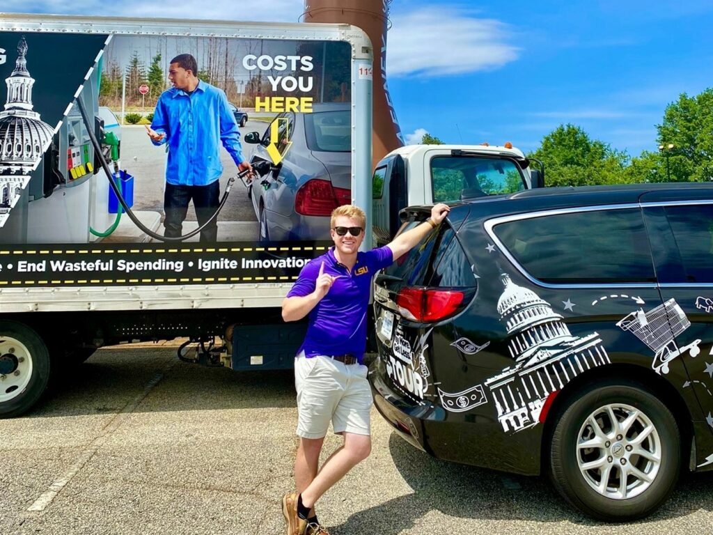 Spencer Evans stands with the True Cost of Washington Tour truck and van, the vehicles that powered AFP's effort to help Americans fight inflation. 