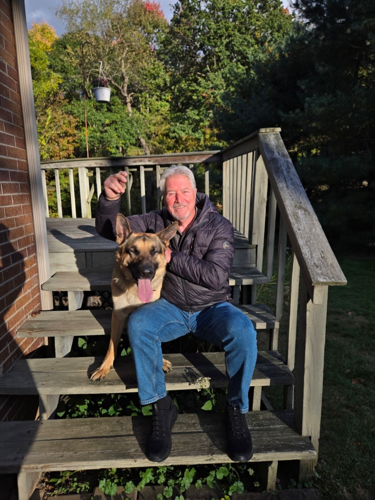 Toni Corsi sits on steps with dog
